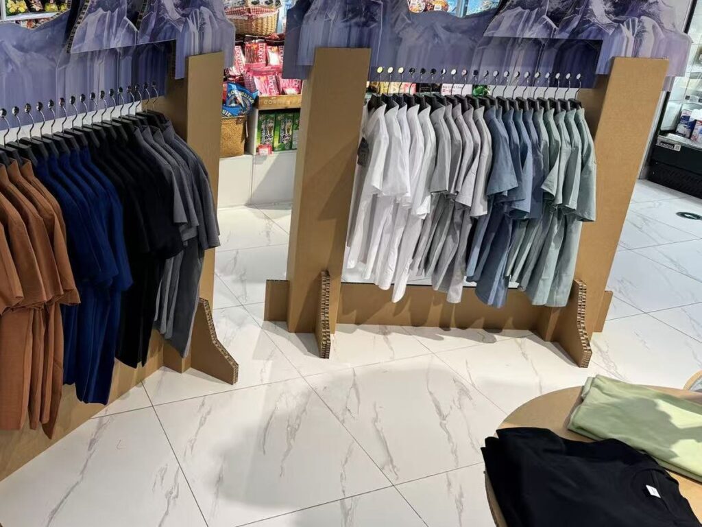Garments on cardboard display rails in store