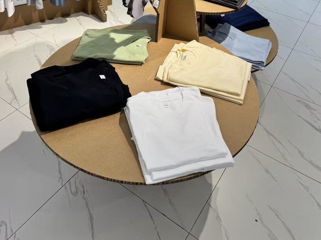 Folded tees on a round cardboard display table